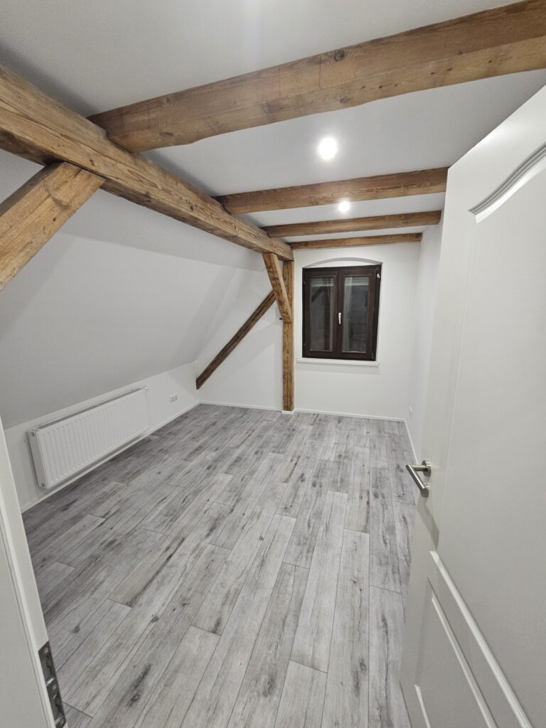 Modern ausgebautes Dachgeschoss mit Dachfenster nach der Renovierung.